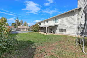 Rear view of house with a sunroom and a yard