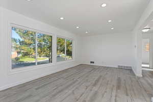 Empty room with light hardwood / wood-style flooring and a healthy amount of sunlight