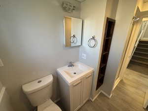 Bathroom featuring wood-type flooring, vanity, and toilet