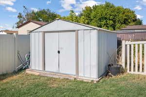 View of outdoor structure featuring a lawn