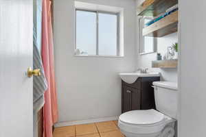 Bathroom featuring vanity, tile patterned flooring, and toilet