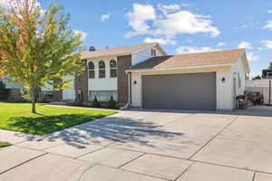 View of front of property with a garage and a front yard