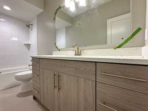 Full bathroom with tile patterned flooring, vanity, toilet, and tiled shower / bath