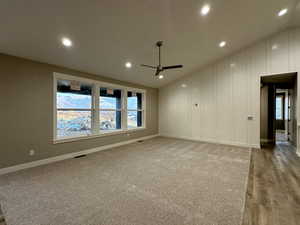 Empty room featuring ceiling fan, light hardwood / wood-style floors, and lofted ceiling