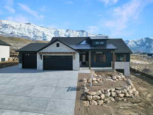 View of front of home with covered porch, a mountain view, and a garage