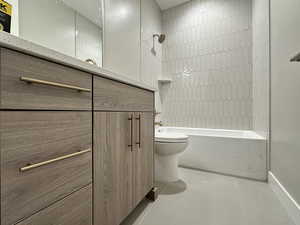 Bathroom featuring toilet, tiled shower / bath combo, and tile patterned floors