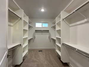 Walk in closet with dark carpet