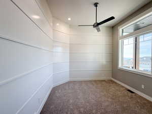 Empty room featuring carpet flooring and ceiling fan