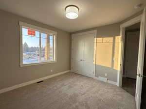 Unfurnished bedroom with carpet and a closet