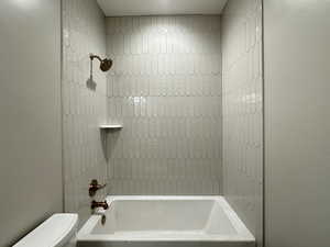 Bathroom with toilet and tiled shower / bath