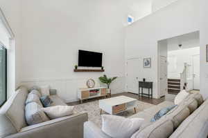 Living room with a towering ceiling and wood-type flooring