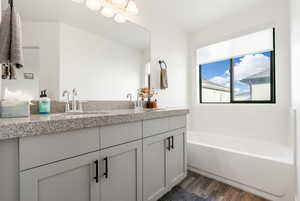 Bathroom with vanity, hardwood / wood-style floors, and a bathtub