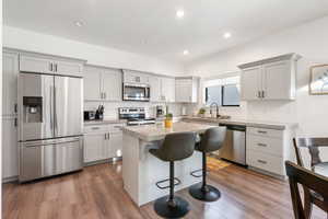 Kitchen featuring a breakfast bar area, a center island, dark hardwood / wood-style floors, and stainless steel appliances