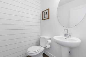 Bathroom featuring toilet and wooden walls