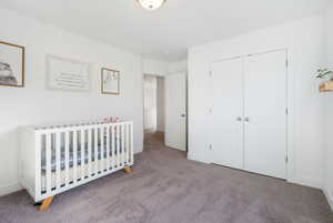 Bedroom featuring light carpet and a closet