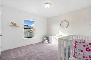 Carpeted bedroom with a crib