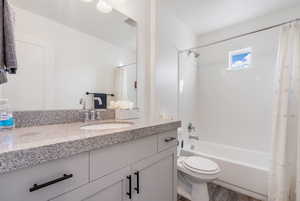 Full bathroom with vanity, toilet, shower / bath combo, and wood-type flooring