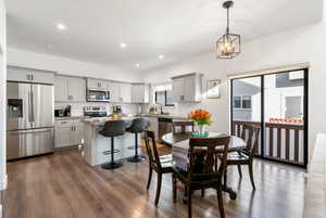 Dining room featuring sink, dark wood-type flooring, and a notable chandelier