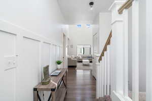 Hallway featuring a high ceiling and dark hardwood / wood-style flooring