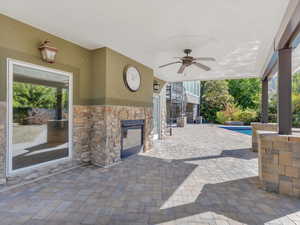 Covered patio with outdoor fireplace and basement entrance