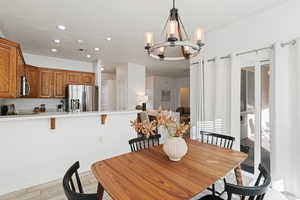 Dining room with light hardwood / wood-style floors and an inviting chandelier