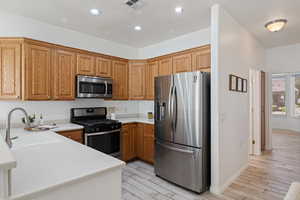 Kitchen featuring sink, stainless steel appliances, and light hardwood / wood-style flooring