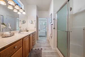 Bathroom with hardwood / wood-style floors, an enclosed shower, and vanity