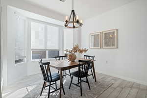 Dining area with light wood-type flooring and a chandelier