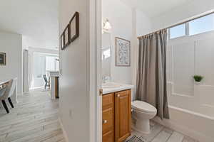 Full bathroom featuring shower / tub combo, hardwood / wood-style floors, vanity, and toilet