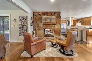 Living room with a fireplace, light hardwood flooring