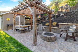 View of patio with a fire pit and a pergola