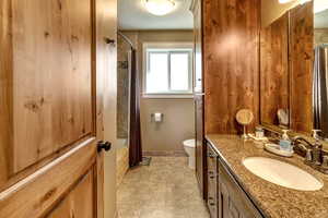 Full bathroom featuring shower / bath combination with curtain, vanity, toilet, a textured ceiling, and tile patterned flooring