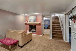 Carpeted living room with a textured ceiling