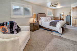 One of two owner's suites. Carpeted bedroom with ceiling fan and a textured ceiling