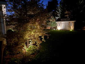 Yard at night featuring a storage unit