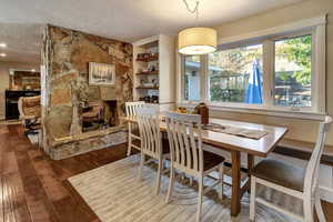 Dining room featuring a textured ceiling, a fireplace, and hardwood / wood-style floors