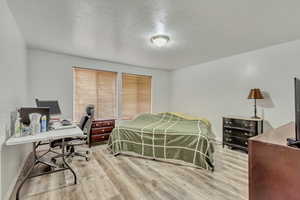 Bedroom featuring a textured ceiling and light hardwood / wood-style flooring