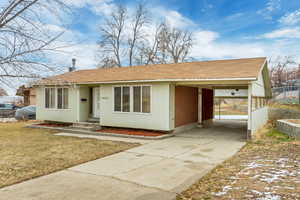 Ranch-style house with a front lawn and a carport