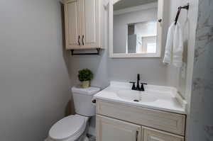 Bathroom with crown molding, toilet, and vanity