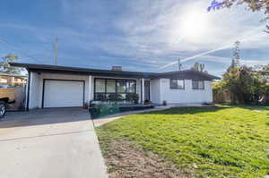 Ranch-style home with a garage and a front lawn