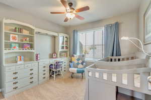 Carpeted bedroom featuring a ceiling fan