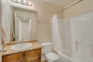 Full bathroom with shower / tub combo with curtain, vanity, and toilet