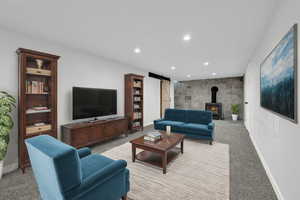 Living room with a barn door, a wood stove, and light carpet