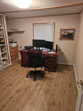 Home office featuring a textured ceiling and hardwood / wood-style flooring