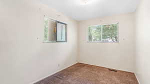 Carpeted empty room featuring baseboards