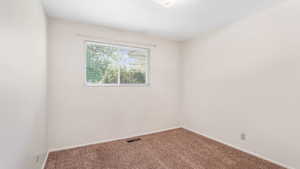 Carpeted spare room with baseboards