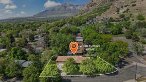 Aerial view of property and surrounding area featuring a mountain backdrop and property parcel outlined