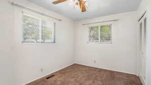 Unfurnished bedroom with carpet floors, a closet, baseboards, and ceiling fan