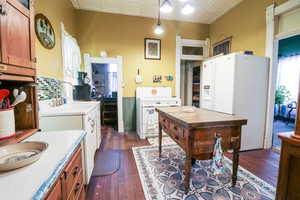 Kitchen featuring sink, dark wood-type flooring, and white appliances