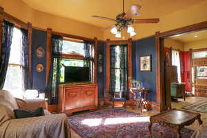 Living room featuring hardwood / wood-style flooring, a healthy amount of sunlight, and ceiling fan